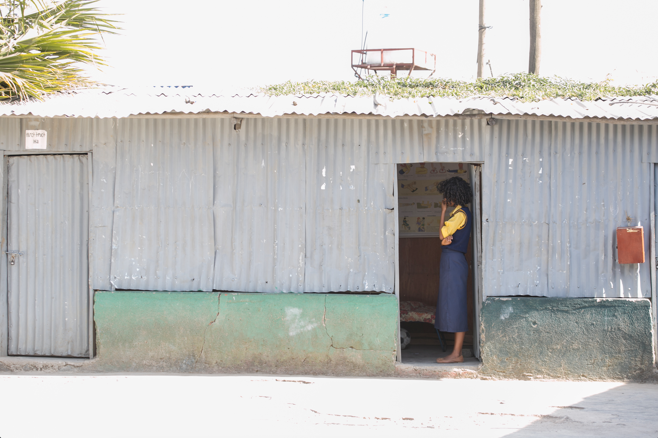 tin building with a teacher in front