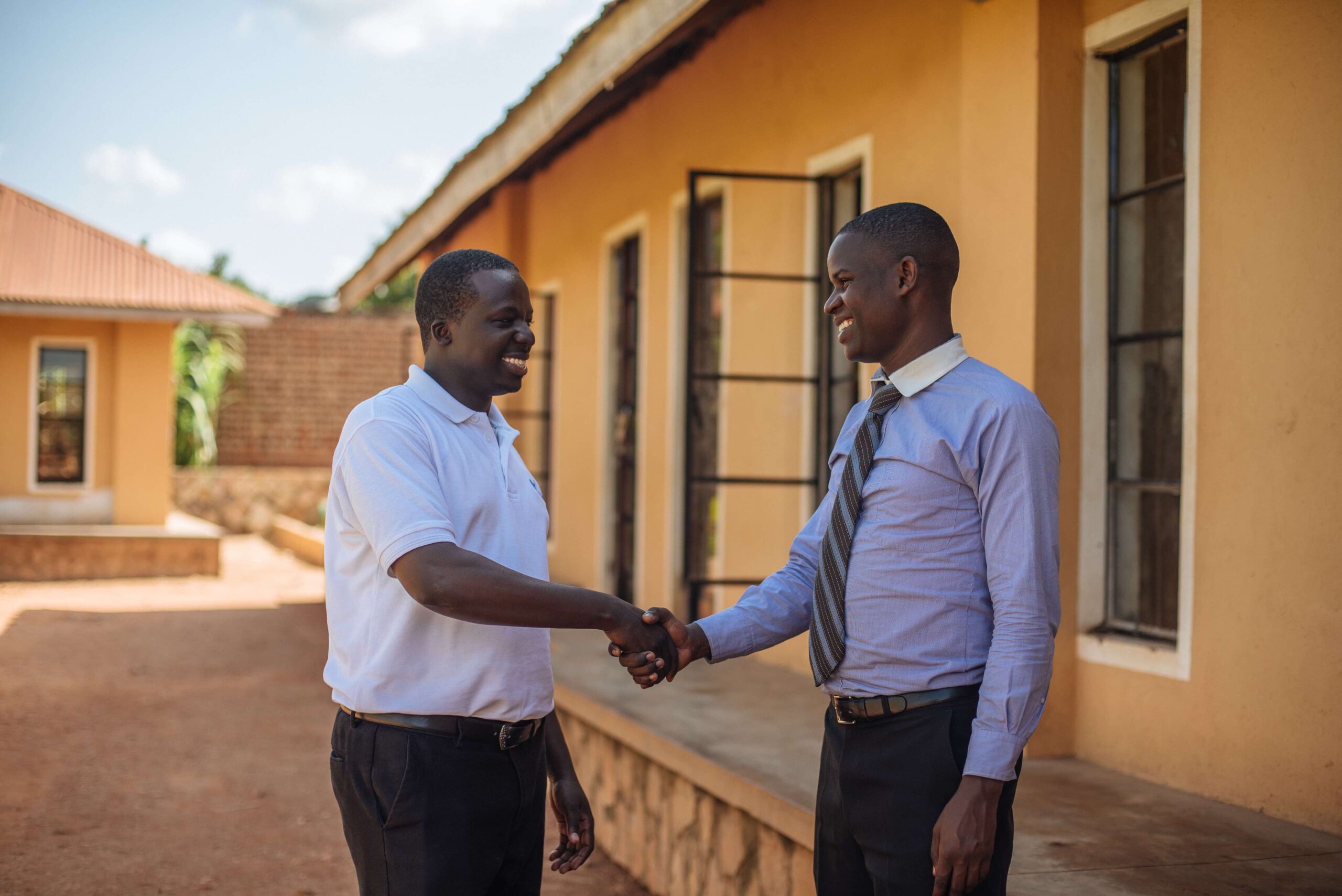 two people in uganda shaking hands