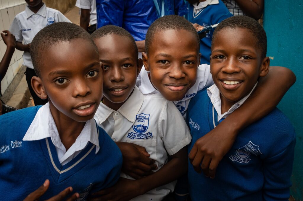 students in Uganda standing and smiling