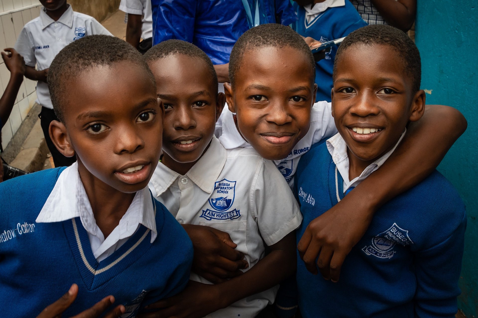 students in Uganda standing and smiling